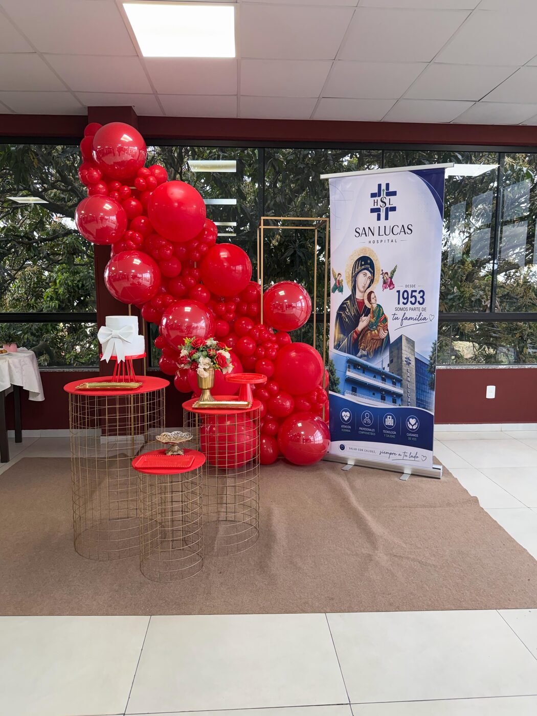 Ambientación con globos y el banner institucional en el patio de comidas del hospital