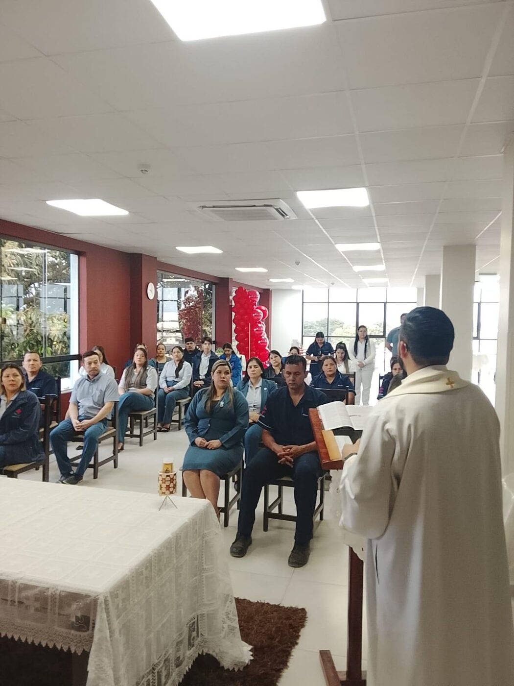 Sacerdote celebrando la Eucaristía ante el personal del Hospital San Lucas