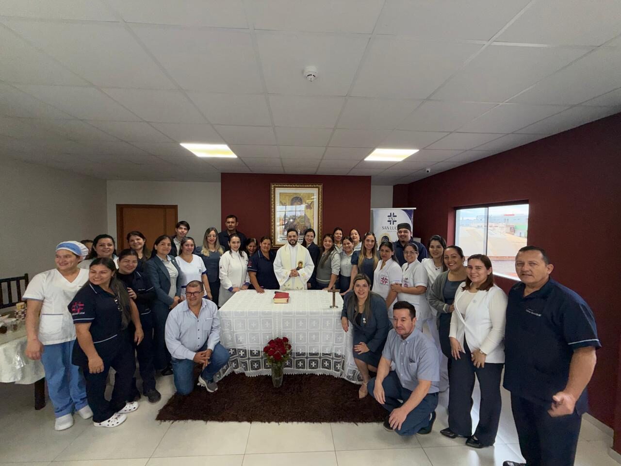Integrantes del plantel del hospital reunidos junto al altar al finalizar la misa