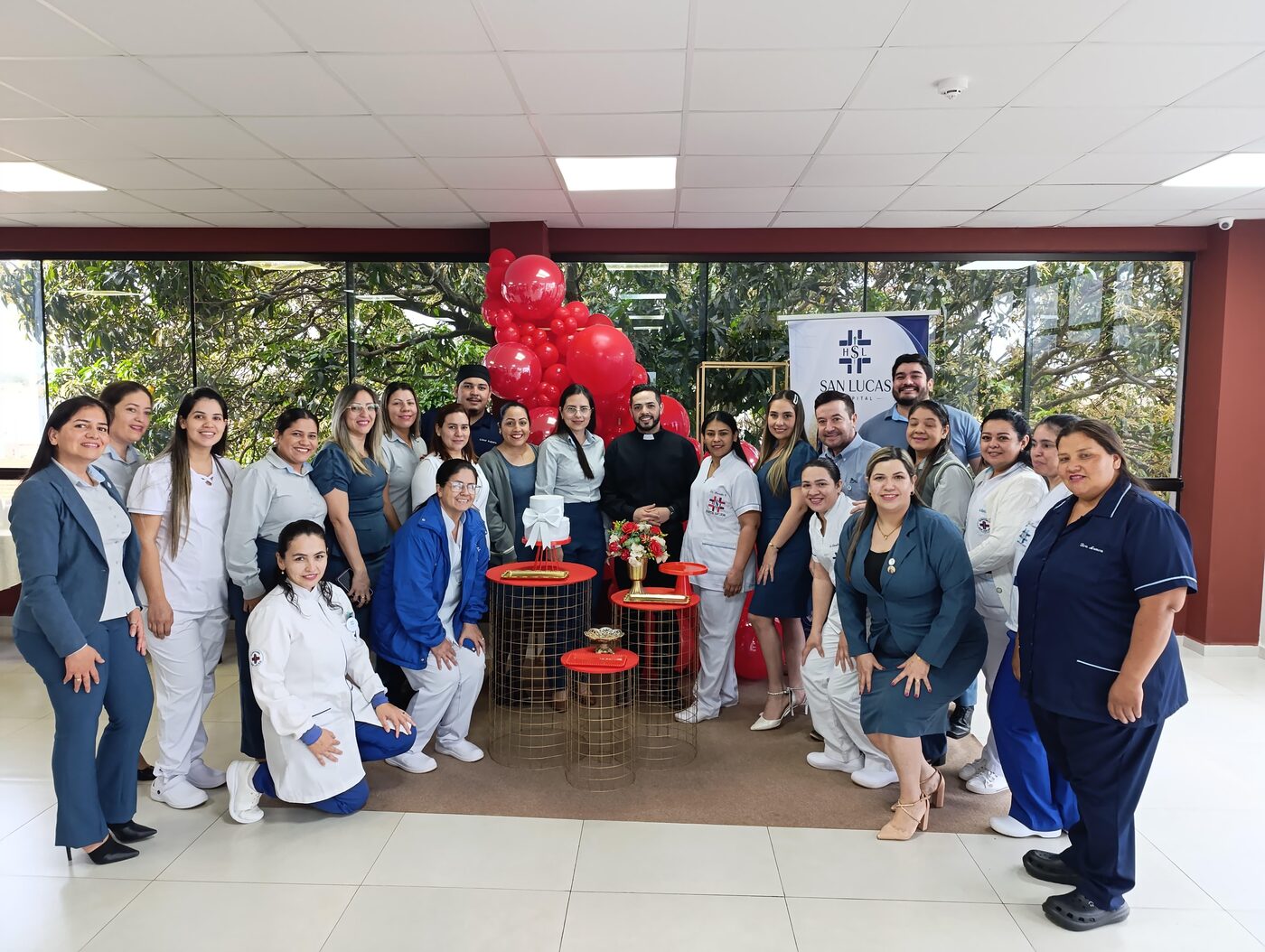 Personal del hospital junto a la torta de aniversario durante el compartir