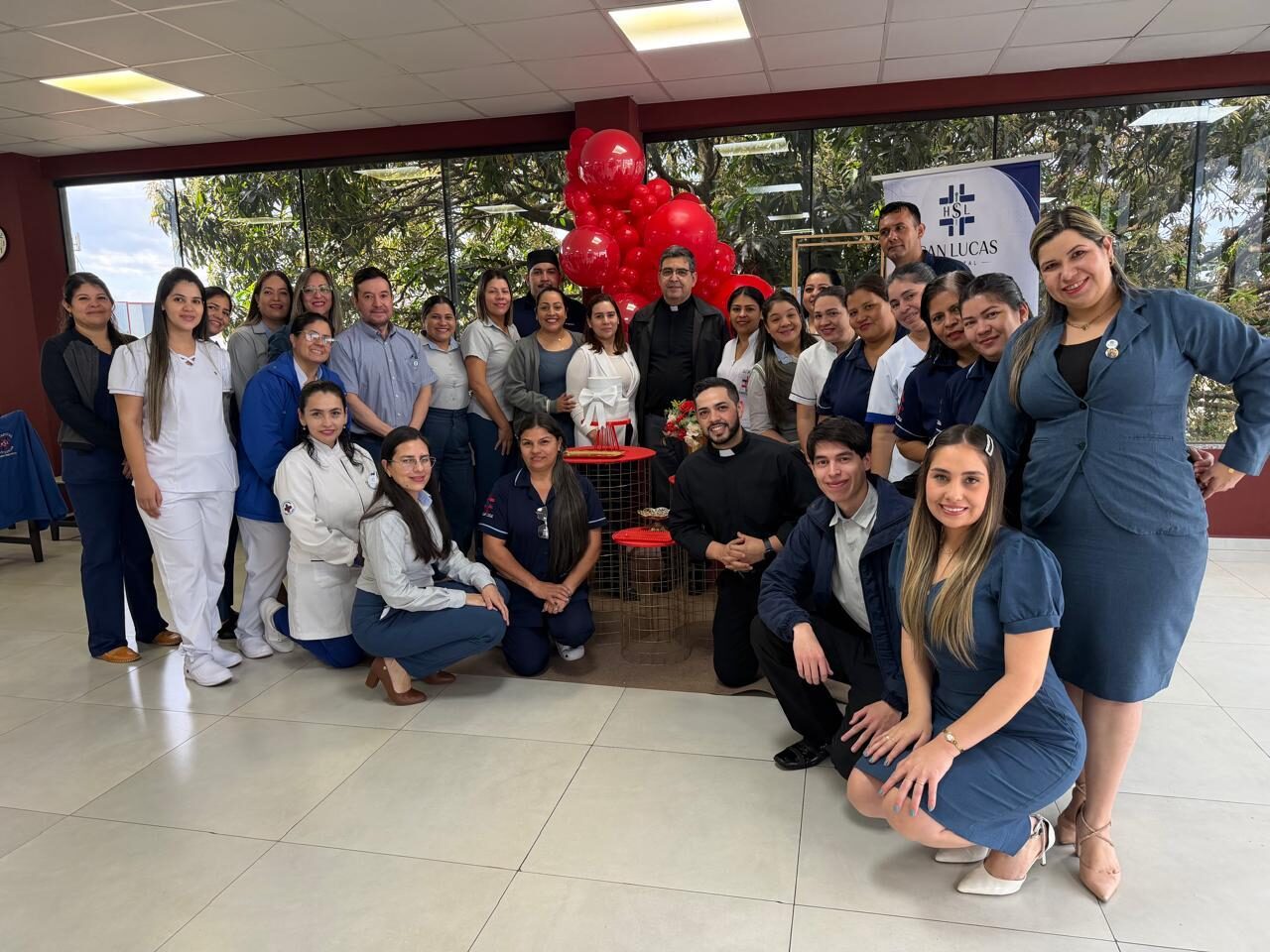 Colaboradores de las distintas áreas del hospital posando junto al banner institucional