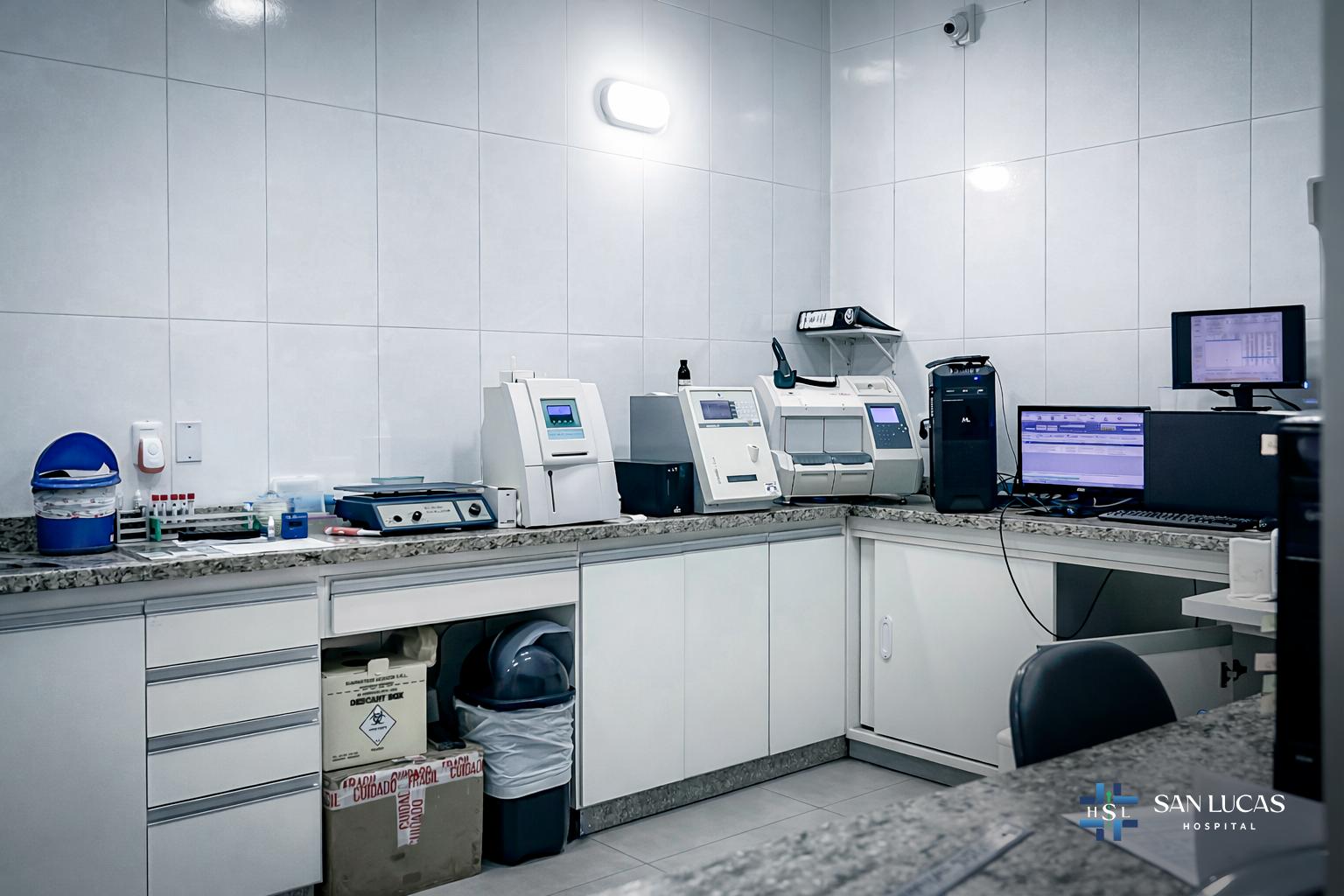Mesada del laboratorio con analizadores automáticos y estación de informes del Hospital San Lucas